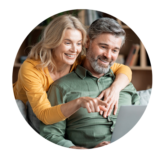 Älteres Paar schaut gut gelaunt auf den Laptop